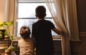 Des enfants regardent par la fenêtre. (Photo by Kelly Sikkema on Unsplash)